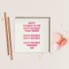 Duurzame wenskaart grafiquelien, vierkant, dubbele wenskaart met envelop, en rood-roze verjaardagsliedtekst happy birthday, met een paar macarons en gouden rietjes en confetti als fotografie props