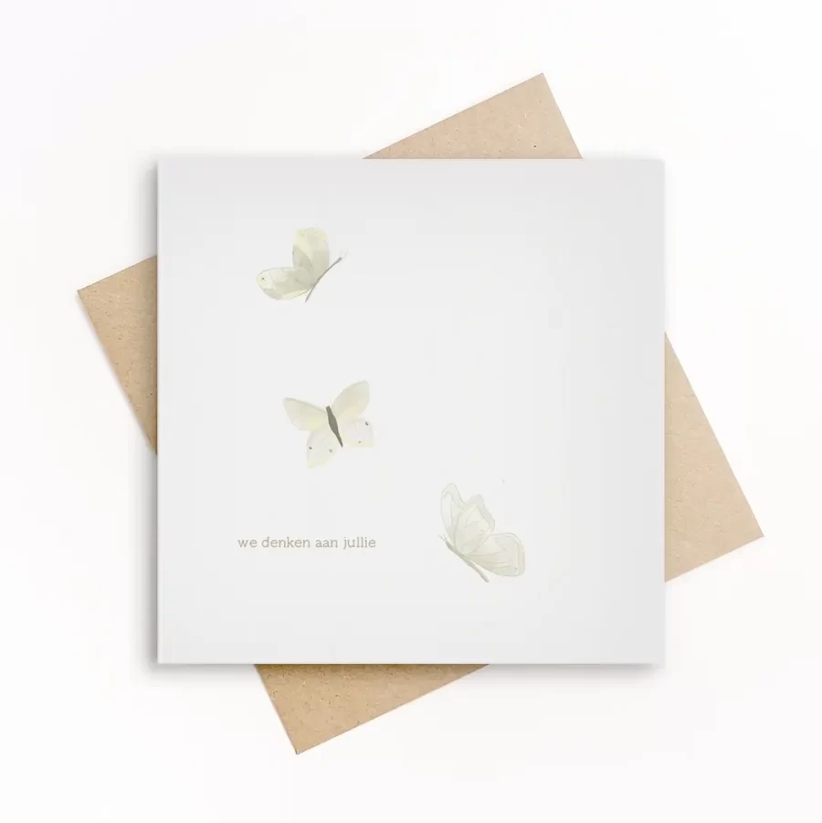 Eco-friendly wenskaart met drie zacht geïllustreerde witte vlinders en de tekst we denken aan jullie, op wit papier met kraft envelop.