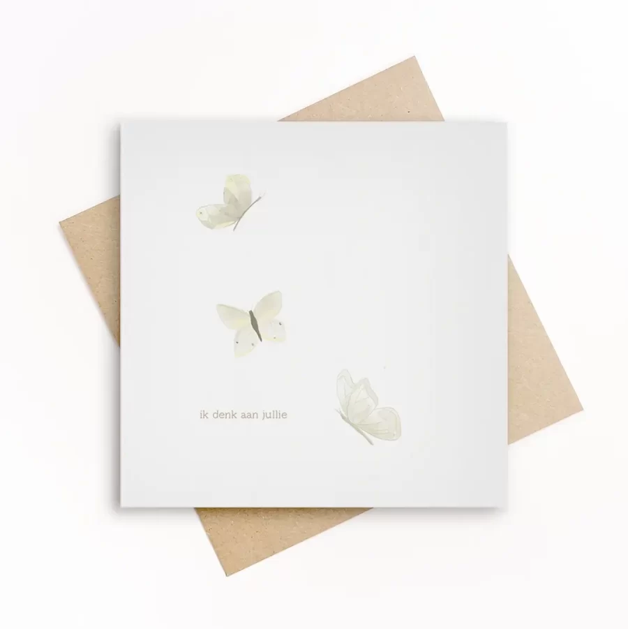 Eco-friendly wenskaart met drie zacht geïllustreerde witte vlinders en de tekst ik denk aan jullie, op wit papier met kraft envelop.