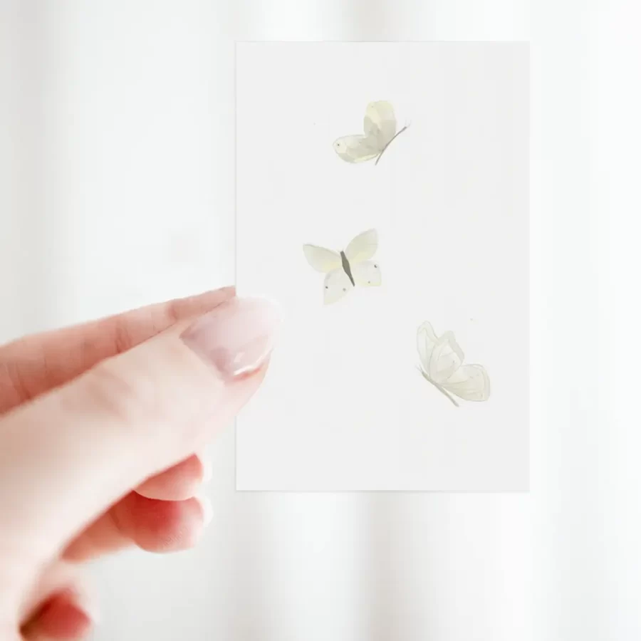 Duurzaam bloemenkaartje met witte vlinders in hand gehouden