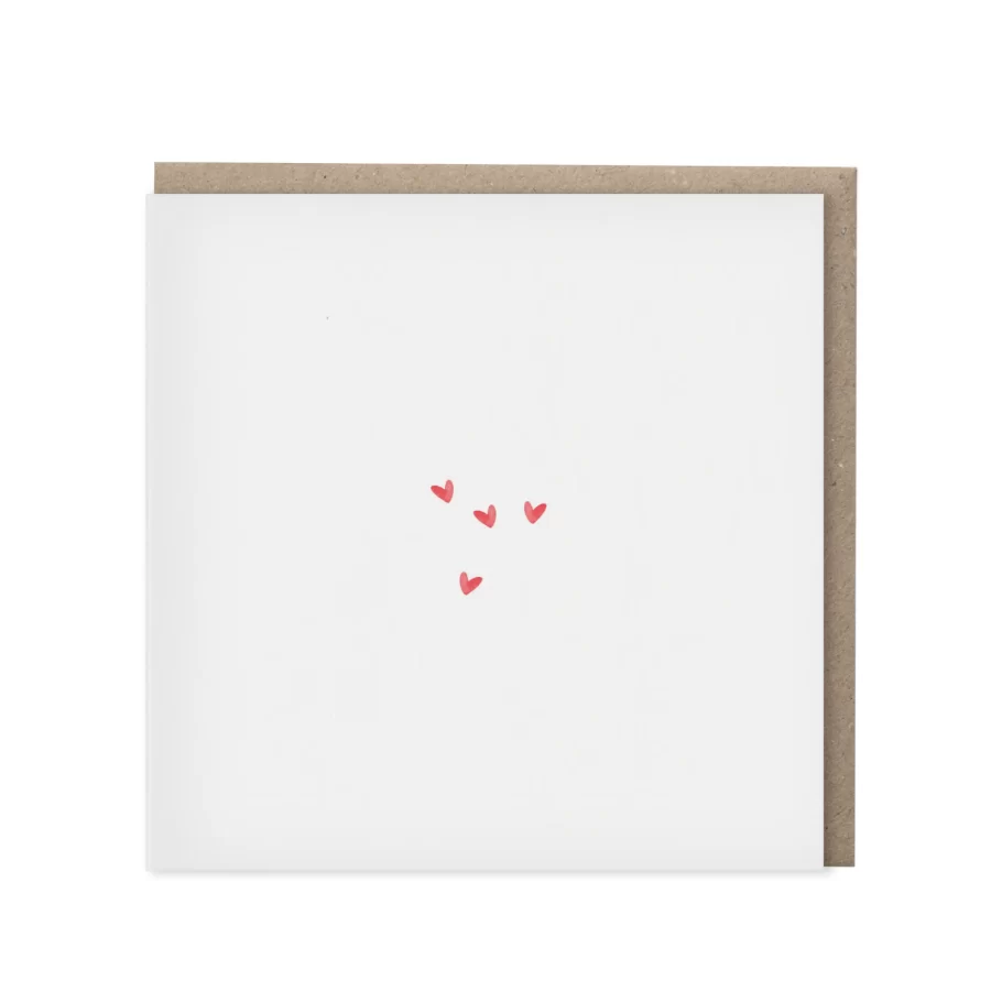 Vierkante wenskaart met vier kleine rode aquarel hartjes op een wit vlak, met kraft envelop op de achtergrond