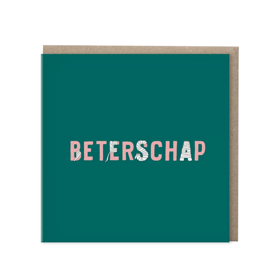 Vierkante donkergroene wenskaart met het woord Beterschap in roze letters waarbij enkele letters zijn ingepakt als verband, met kraft envelop op de achtergrond
