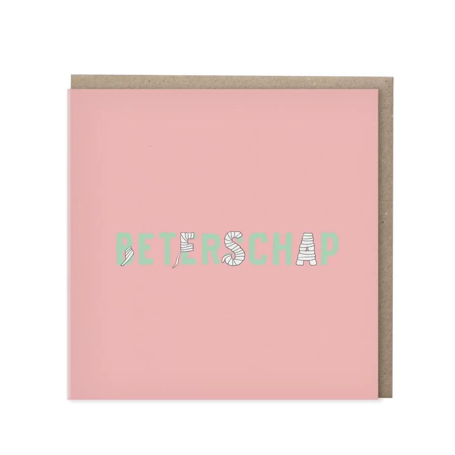 Vierkante roze wenskaart met het woord Beterschap in mintgroene letters waarbij enkele letters zijn ingepakt als verband, met kraft envelop op de achtergrond